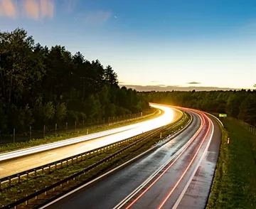 Auto sfrecciano su un'autostrada durante la sera