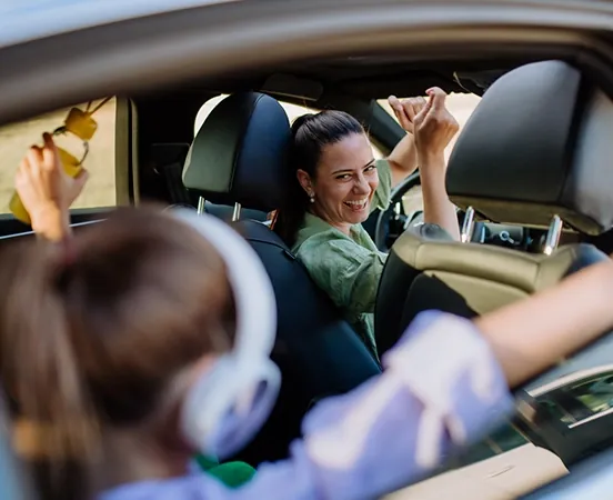 A woman and the daughter have fun and smiles in a car