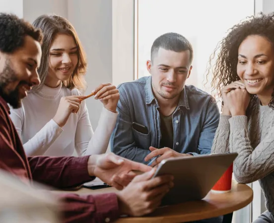 Alcuni colleghi sorridenti lavorano assieme guardando il monitor di un computer